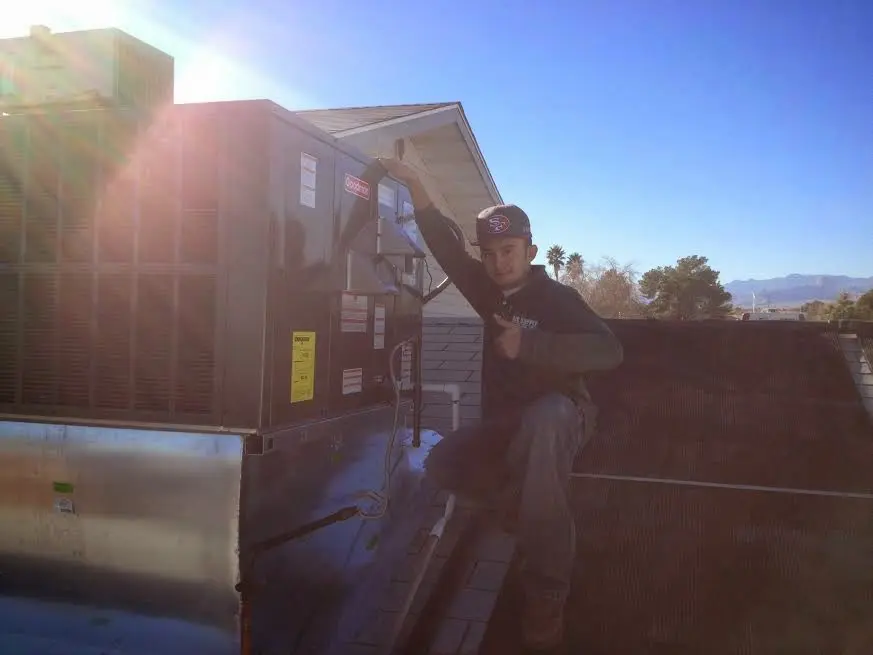 HVAC technician performing AC Tune-Up on a rooftop unit in Bellaire